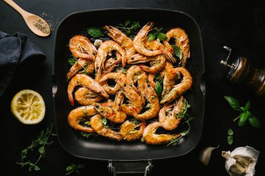 Lezzetli, kavrulmuş karides, tavada baharat ve siyah arka planda malzemeler. Kopya uzayı ile Üst Görünüm. Yemek Geçmişi İtalyan Mutfağı Konsepti