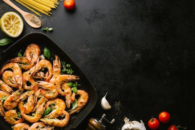 Lezzetli, kavrulmuş karides, tavada baharat ve siyah arka planda malzemeler. Kopya uzayı ile Üst Görünüm. Yemek Geçmişi İtalyan Mutfağı Konsepti