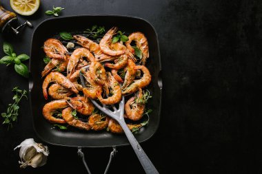 Lezzetli, kavrulmuş karides, tavada baharat ve siyah arka planda malzemeler. Kopya uzayı ile Üst Görünüm. Yemek Geçmişi İtalyan Mutfağı Konsepti