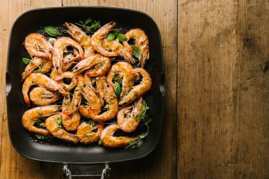 Lezzetli iştah açıcı Kızarmış karides karides ile baharat ahşap masa üzerinde tava üzerinde. Üstten görünüm kopya alanı ile. Gıda arka plan İtalyan mutfak konsepti