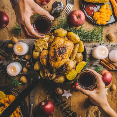 Noel lezzetli tavuk yemek masası üzerinde tava üzerinde. Noel yemeği kavramı. Şarap içme ve Noel akşam yemeği yiyen insanlar. Yukarıdan görüntülemek. 