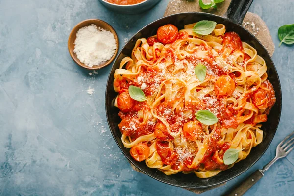 Lezzetli iştah açıcı spagetti domates sos ve peynir tablo üzerinde tava üzerinde. Yukarıdan görüntülemek