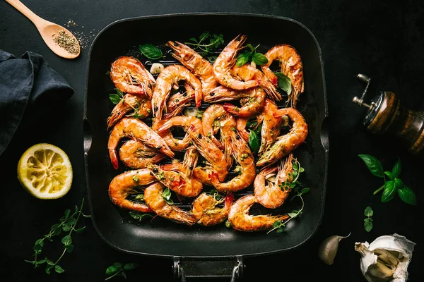 Lezzetli, kavrulmuş karides, tavada baharat ve siyah arka planda malzemeler. Kopya uzayı ile Üst Görünüm. Yemek Geçmişi İtalyan Mutfağı Konsepti