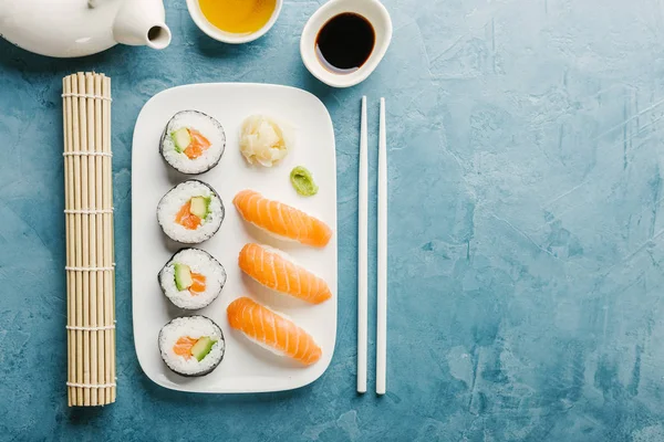 Sushi Avokádem Lososa Podávané Talíř Zelený Čaj Modrém Stole Vodorovný — Stock fotografie