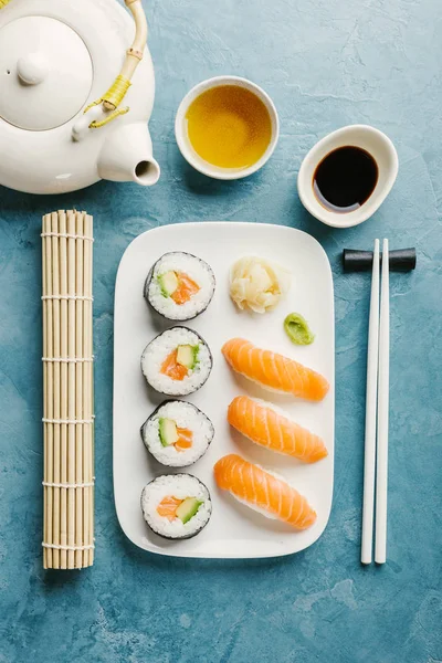 Sushi Avokádem Lososa Podávané Talíř Zelený Čaj Modrém Stole Vodorovný — Stock fotografie
