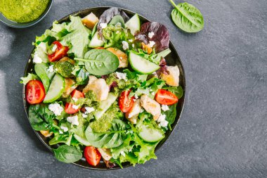 tavuk, domates, salatalık, pesto sos ve peynir beyaz kase lezzetli taze salata üstten görünüm gri masada