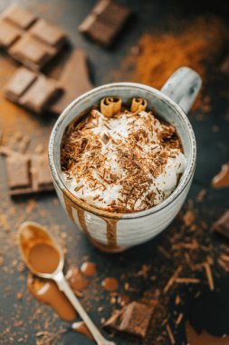 sıcak çikolata çikolata parçaları ve kupa karanlık masada krema ile