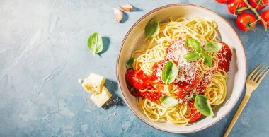 mavi yüzeyi spagetti domates sosu ve parmesan kase ile üstten görünüm
