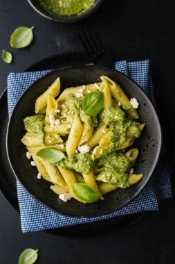 taze sosu pesto ve siyah tablo tabakta servis peynir ile lezzetli iştah açıcı makarna üstten görünüm 