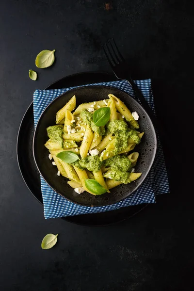 taze sosu pesto ve siyah tablo tabakta servis peynir ile lezzetli iştah açıcı makarna üstten görünüm 