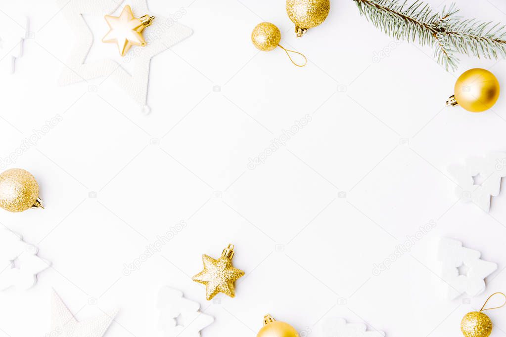 top view of Christmas golden decorative baubles and fir twig isolated on white