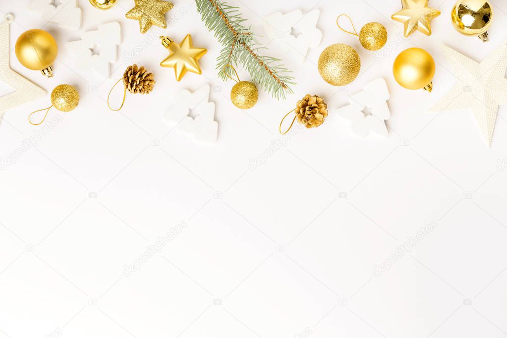 Flat Lay of Christmas golden decorative baubles and fir twig isolated on white