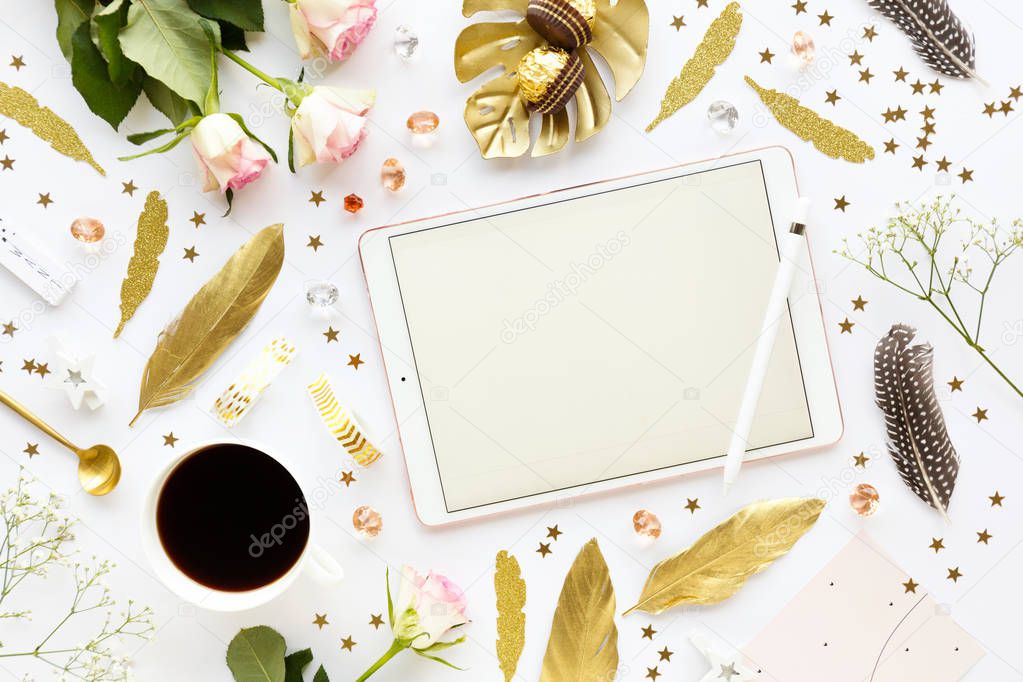 top view of golden decorative elements for christmas with coffee and tablet on white tabletop