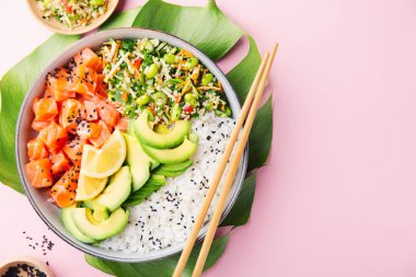 Somon, avokado, pirinç, pembe arka planda edamame ile salata ile servis lezzetli iştah açıcı poke kase