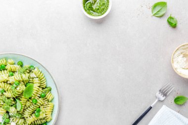 Lezzetli iştah açıcı İtalyan makarna al bronzo pesto sosu, yeşil bezelye, fesleğen ve peynir ile tabakta