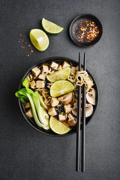 Koyu arka plan üzerinde kase lezzetli Asya Vejetaryen çorba servis