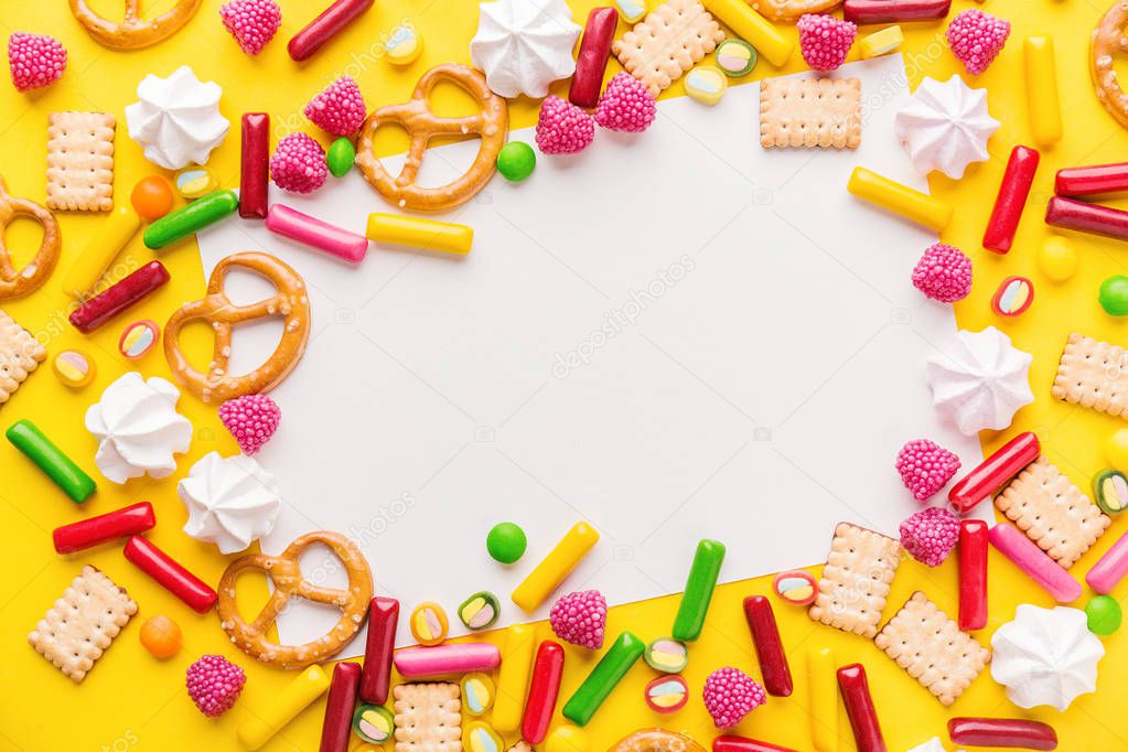 Tasty Colorful Sweets on Yellow Background with copy space
