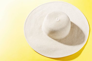 Parlak sarı güneşli arka plan üzerinde hasır şapka
