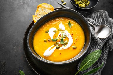 Pumpkin creamy soup served in bowl clipart