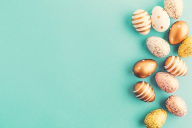 Düz yatıyordu, altın yumurta satırda turkuaz zemin üzerine yerleştirilir. Paskalya arka plan veya Paskalya kavramı. 