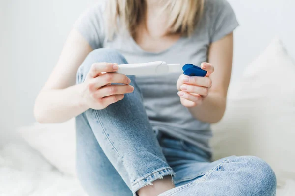 Mujer mirando y comprobando la prueba de embarazo —  Fotos de Stock