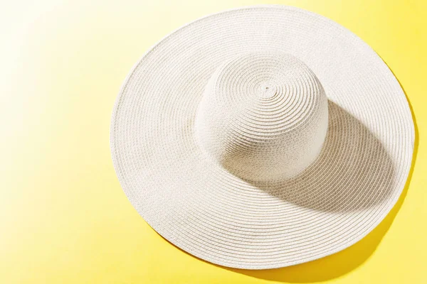 Chapéu de palha no fundo ensolarado amarelo brilhante — Fotografia de Stock