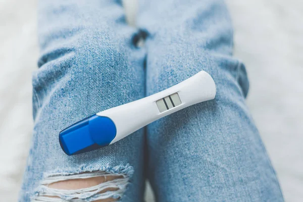 Mulher olhando para teste de gravidez positivo — Fotografia de Stock