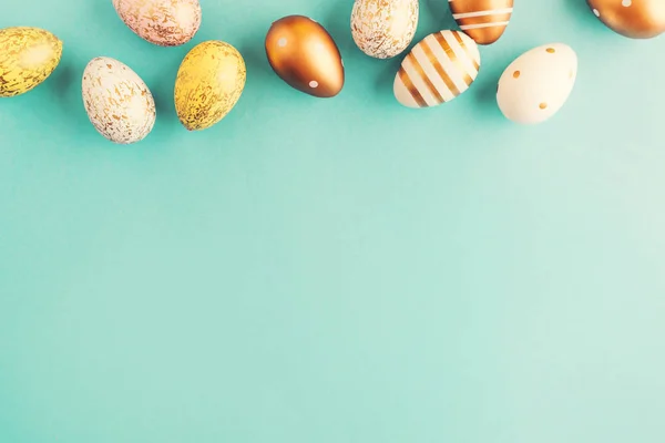 Plochý Ležela Golden Velikonoční Vejce Řadě Kladen Tyrkysové Pozadí Velikonoční — Stock fotografie