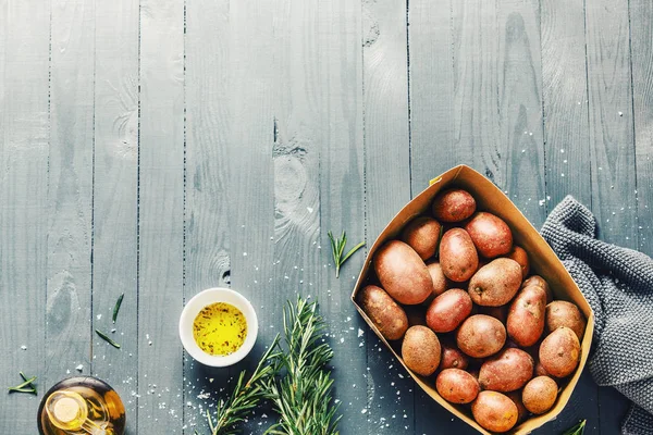 Patatas orgánicas crudas con especias en mesa de madera — Foto de Stock