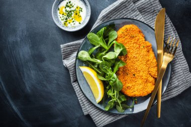 Klasik Alman ya da Avusturyalı şnitzel. Tabakta salata var.. 