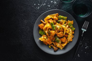 Tavuk ve soslu tagliatelle ile lezzetli iştah açıcı makarna. Koyu arkaplan. 