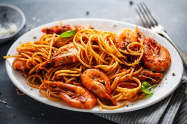 Karides ve domates soslu makarna koyu arkaplanda servis edilir. Yakın çekim.. 