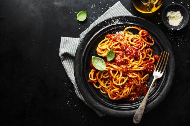 Koyu arkaplanda servis edilen domates soslu lezzetli spagetti makarnası.. 