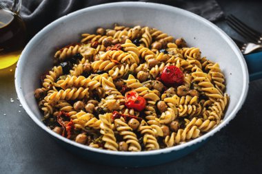 Sebzeli ve tavada pişmiş ve servis edilmiş nohutlu lezzetli vejetaryen makarna. Yakın çekim.. 