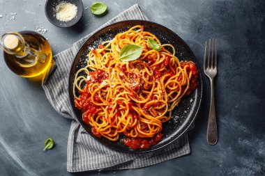 Koyu arkaplanda servis edilen domates soslu lezzetli spagetti makarnası.. 