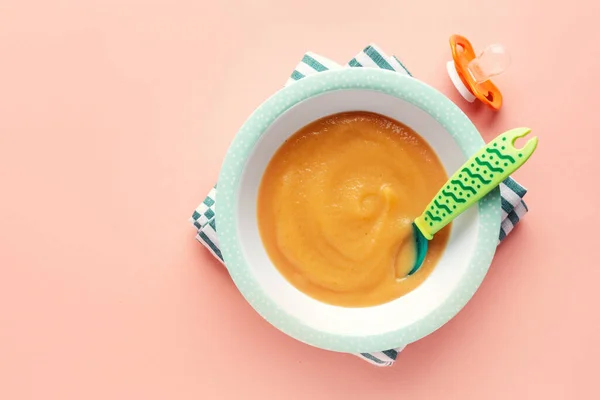 Pastel arka planda servis edilen bebek maması için elma püresi. Bebek maması konsepti. 