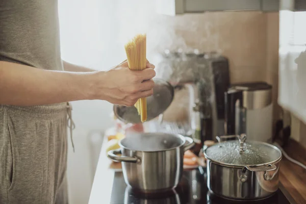 キッチンの自宅でパスタスパゲティを調理する男 家庭料理やイタリア料理のコンセプト — ストック写真