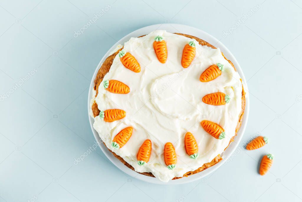 Carrot easter cake with frosting and small carrots deco on top. View from above. Easter concept. 