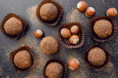 Çikolata petit four tatlılar sarmalayıcı üzerinde siyah arka plan, darkmood fotoğraf kavramı, fındık ile görünümü top