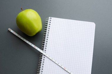 boş defter ile elma ve ölçüm bandı