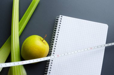 defter ile elma, kereviz ve ölçüm bandı