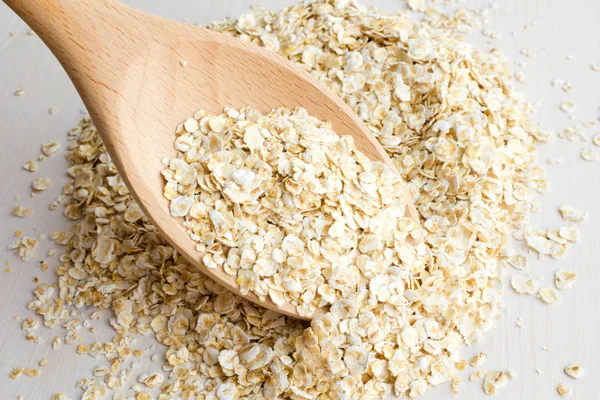 Rolled oats in big wooden spoon — Stock Photo, Image