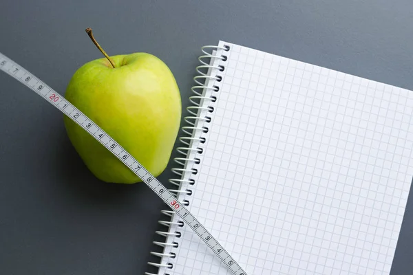 Blank notebook with apple and measuring tape Stock Picture