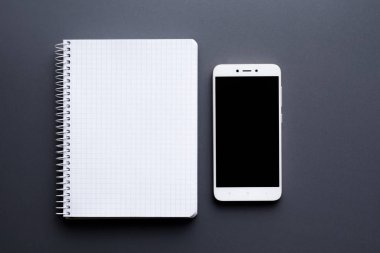 boş beyaz defter ile smartphone üzerinde gri Masaüstü