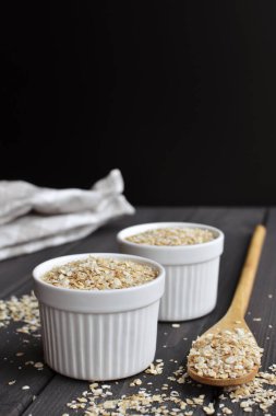 Kase ve kaşık koyu ahşap masa arka plan üzerinde yulaf, kopyalama alanı