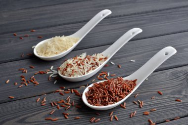 Koyu masa arka plan üzerinde kaşık karışık organik çiğ pirinç