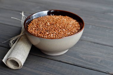 ahşap arka plan üzerinde keten tuval ile kase keten tohumu