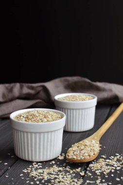 Kase ve kaşık koyu ahşap masa arka plan üzerinde yulaf, kopyalama alanı