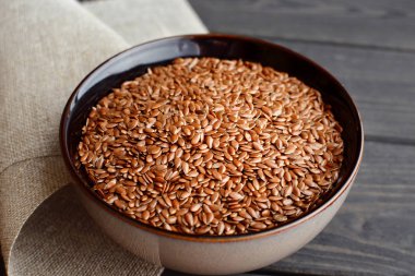 ahşap arka plan üzerinde keten kumaş ile kase keten tohumu