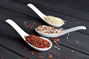 Ahşap masa arka planda kaşık pirinç farklı türleri